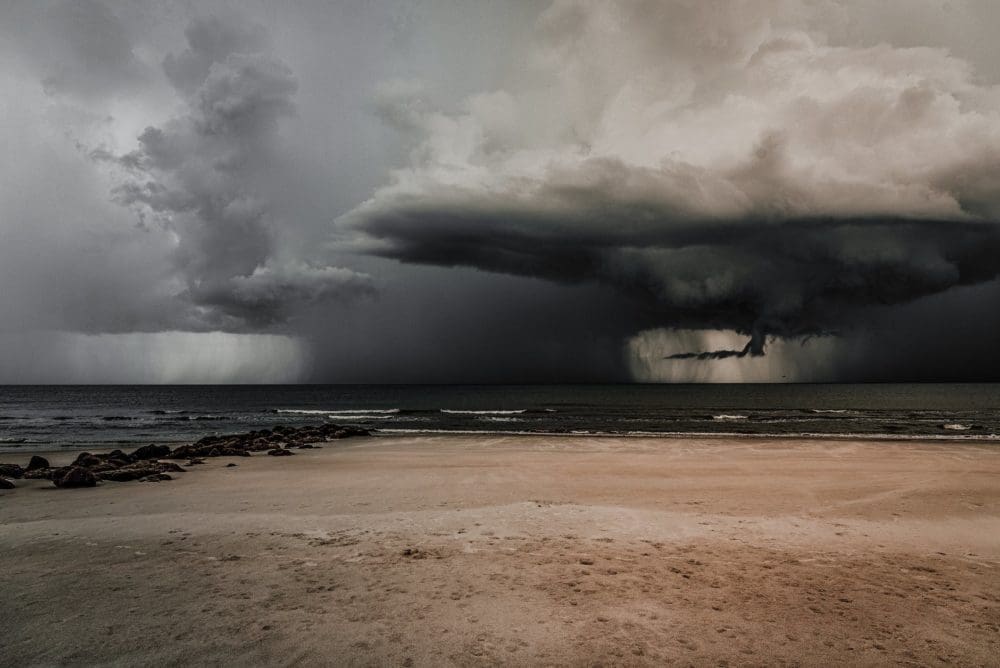 a storm cloud is seen over the ocean