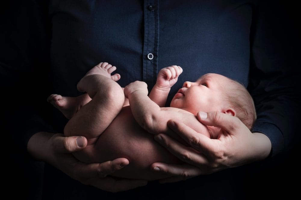 close up photo of a person carrying a baby