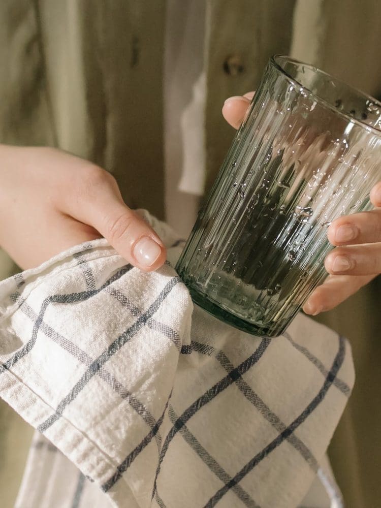 person holding green glass bottle