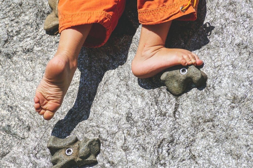 Un bambin grimpe un mur d'escalade